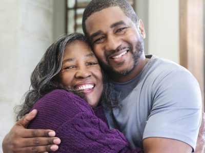 Mother and adult son smiling for maternity DNA testing confirmation.